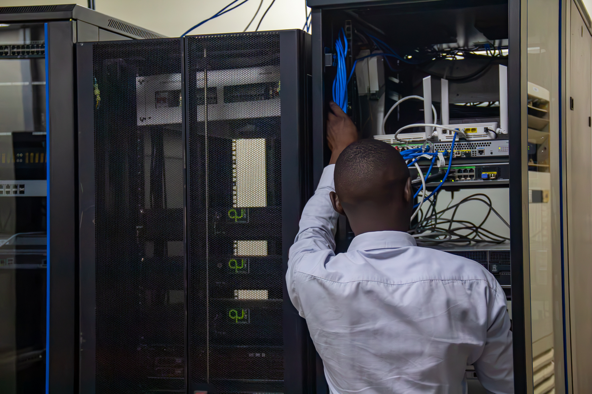 Technician terminating cables in a network rack